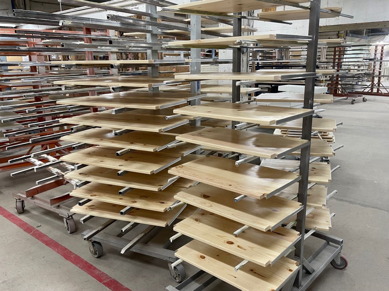 Solid wood shelves moving through the low VOC finishing line