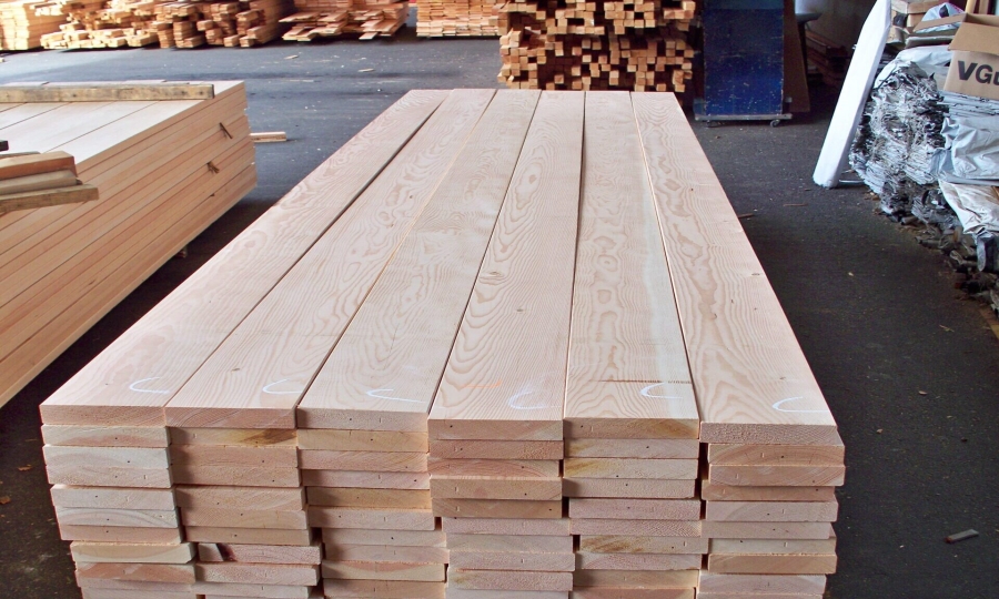Stacks of milled solid wood lumber ready for Lundia closet organizer manufacturing